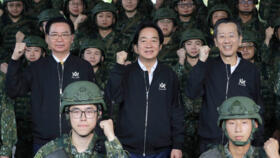 Taiwan President Lai Ching-te, center, cheers with soldiers as he's inspecting Taiwanese reservists participating in reserve military training in Ilan County, Eastern Taiwan, Tuesday, Dec. 2, 2025.