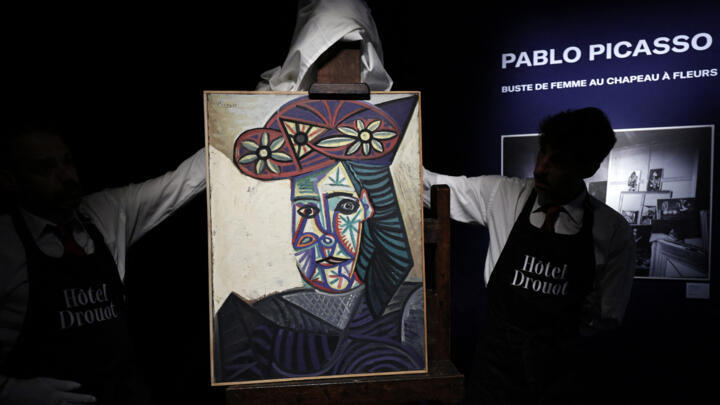 Employees unveal a painting by French artist Pablo Picasso at the Hôtel Drouot auction house in Paris on September 18, 2025.