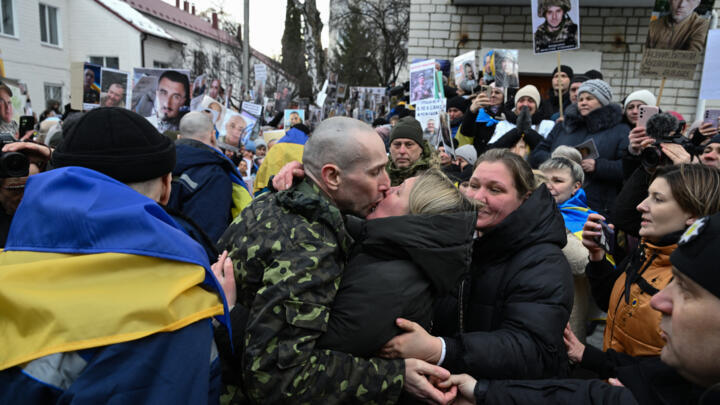 Olesya (C-R) kisses her husband Oleksandr (C-L), 43, a Ukrainian prisoner of war (POW), after he was released from 22 month of Russian captivity following a prisoner exchange in the Chernygiv region.