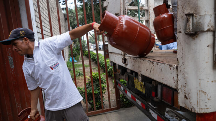 A worker unloads gas cylinders from a truck in Lima, Peru on March 12, 2026