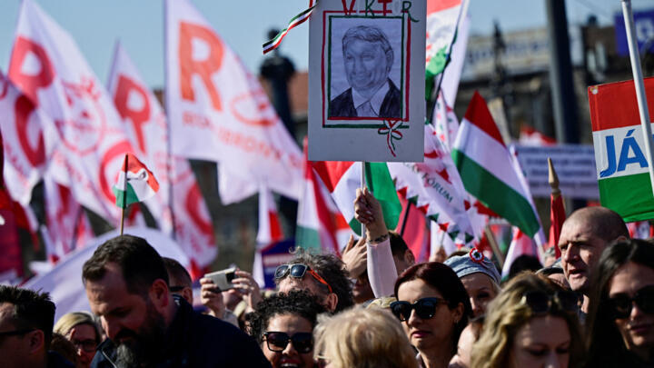 An attendee holds an image of Hungarian Prime Minister Viktor Orban at a pro-government rally named a 'Peace March' during Hungary's National Day celebrations in Budapest, Hungary, March 15, 2026
