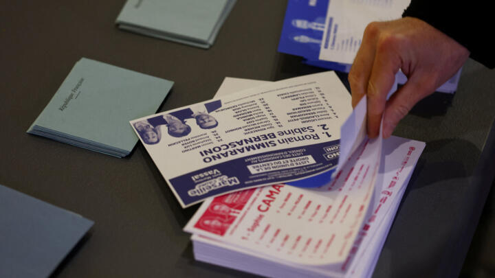 A voter takes ballots at a polling station in Marseille, where the Socialist incumbent saw off a challenge from the far right. 