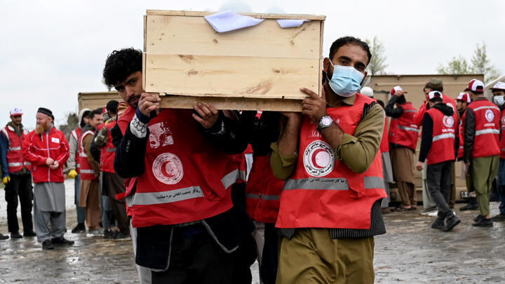 Afghan Red Crescent Society volunteers carry coffins of some of the victims of a Pakistani strike on a drug rehabilitation centre at a mass funeral in Kabul, Afghanistan on March 18, 2026.