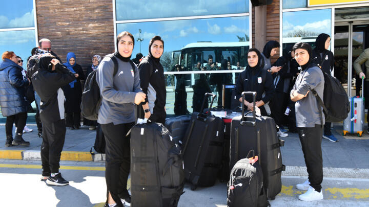 Members of Iran's women's football team at Igdir airport in Turkey, waiting for a bus to take them to the Iranian border