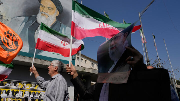 Iranian worshippers walk past a portrait of the late revolutionary founder Ayatollah Ruhollah Khomeini during an anti-Israeli rally in Tehran, Iran, on October 10, 2025.