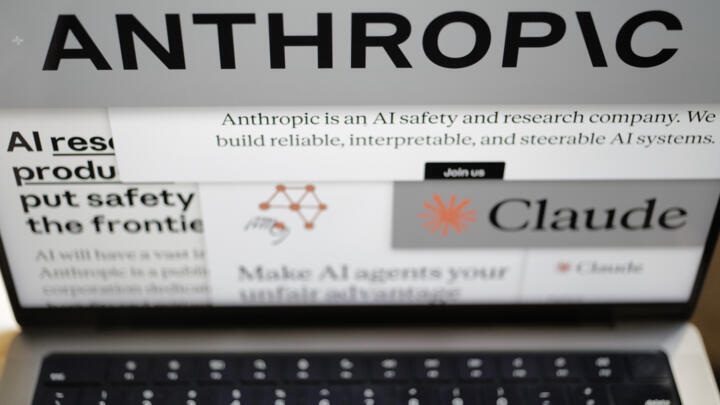 Pages from the Anthropic website and the company's logos are displayed on a computer screen.
