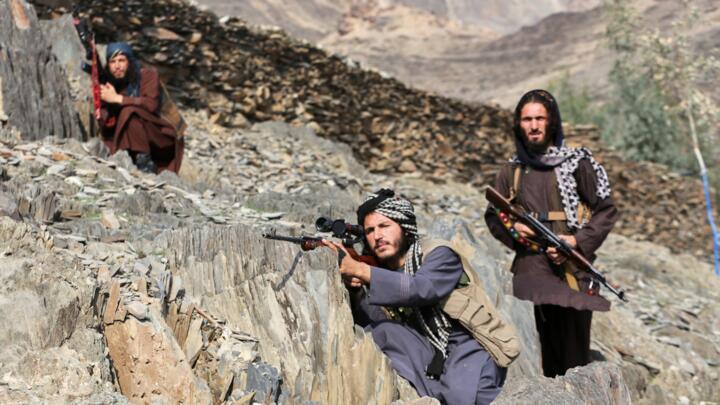 Afghan Taliban soldiers look toward the Pakistani side, with one peering through the sight of his rifle, on the Afghan side of the Torkham border crossing with Pakistan on February 27, 2026.