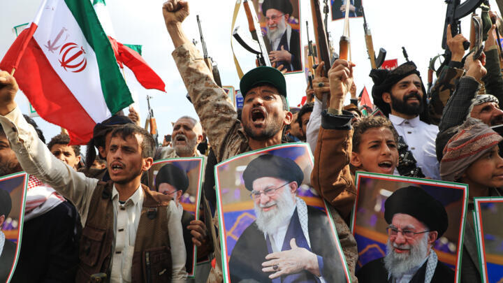 In this file photo, Houthi supporters hold posters of Iranian Supreme Leader Ayatollah Ali Khamenei and Iranian flags during a rally against Israel and the United States in Sanaa, Yemen, Sunday, March