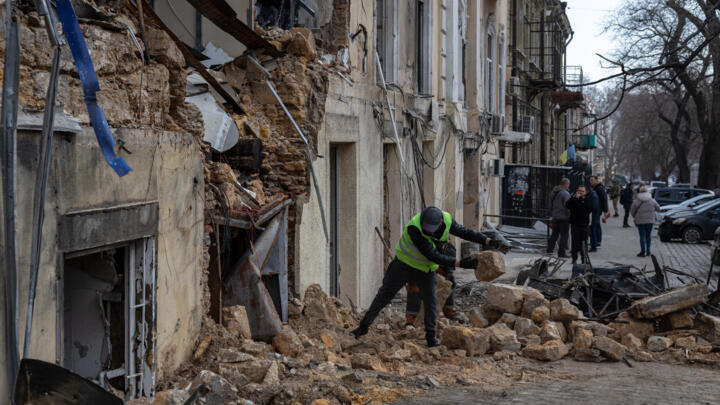 A municipal worker clears debris from a building damaged by a Russian drone strike in Odessa, southern Ukraine, on March 19, 2026.
