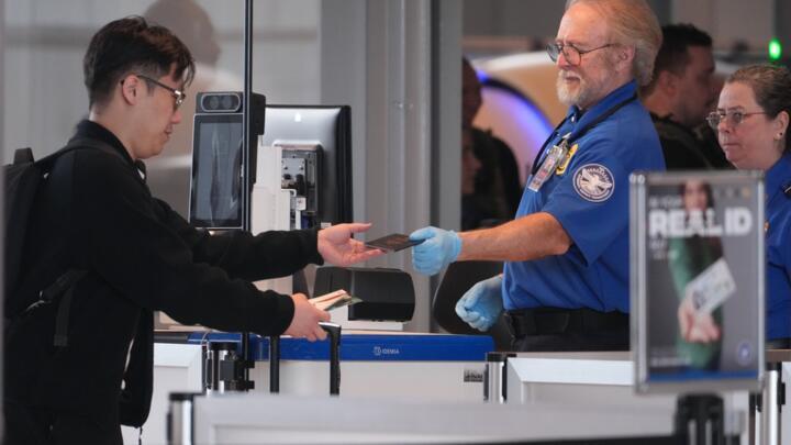 A TSA worker returns a passenger's passport at Greater Pittsburgh International Airport.