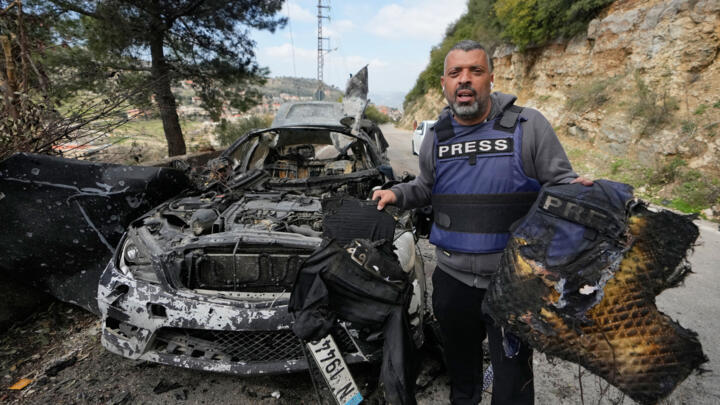 A journalist carries burned safety gear, following an Israeli airstrike on a car in the town of Jezzine, south Lebanon, Saturday, March 28, 2026
