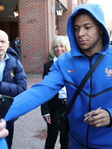 France's forward Kylian Mbappe signs autographs upon arriving at the hotel in Boston on March 24, 2026. 