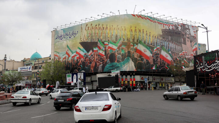 Vehicles move along Enghelab Square in central Tehran on March 25, 2026.